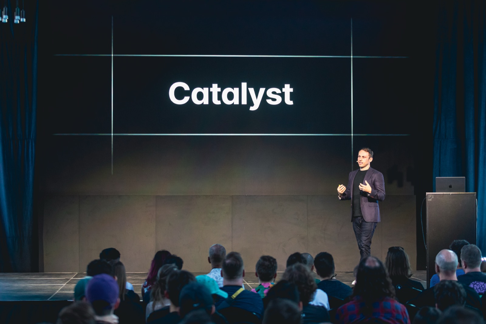 Adam Wathan en el escenario frente a una diapositiva que dice Catalyst